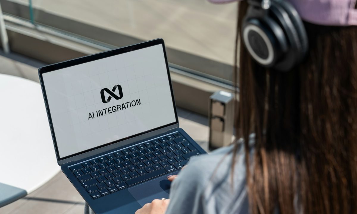 Persona con cuffie davanti a un portatile con la scritta AI Integration sullo schermo